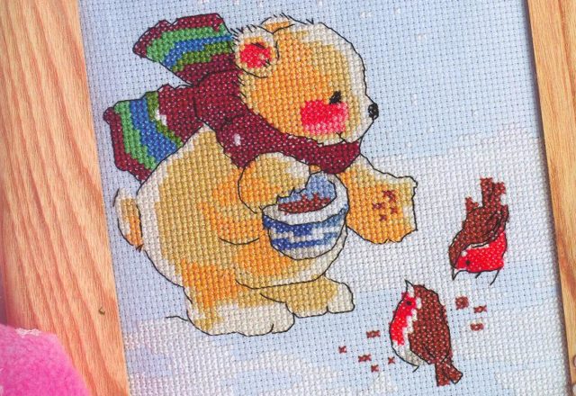 Teddy bear with scarf feeds some birds (1)